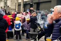 家长等孩子放学校门口抽烟引争议 校门口禁烟难