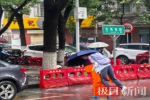 环卫工雨中背50名学生蹚水过马路 平凡善举温暖人心